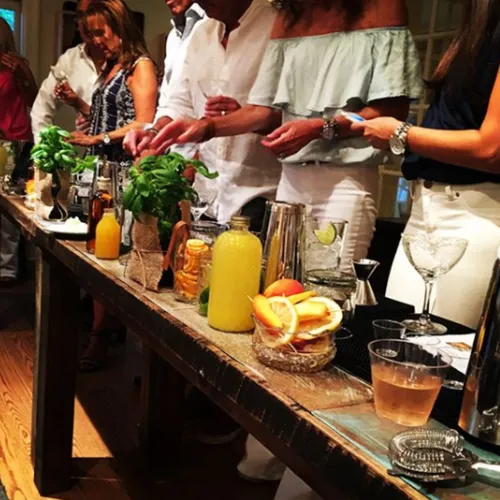 Guests mixing their own cocktails at a long farmhouse table
